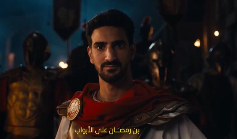 صورة تظهر الإعلان العالمي لصفقة محمد علي بن رمضان مع الاهلي، اللاعب يرتدي قميص الفريق الأحمر ويحتفل بانضمامه الرسمي.